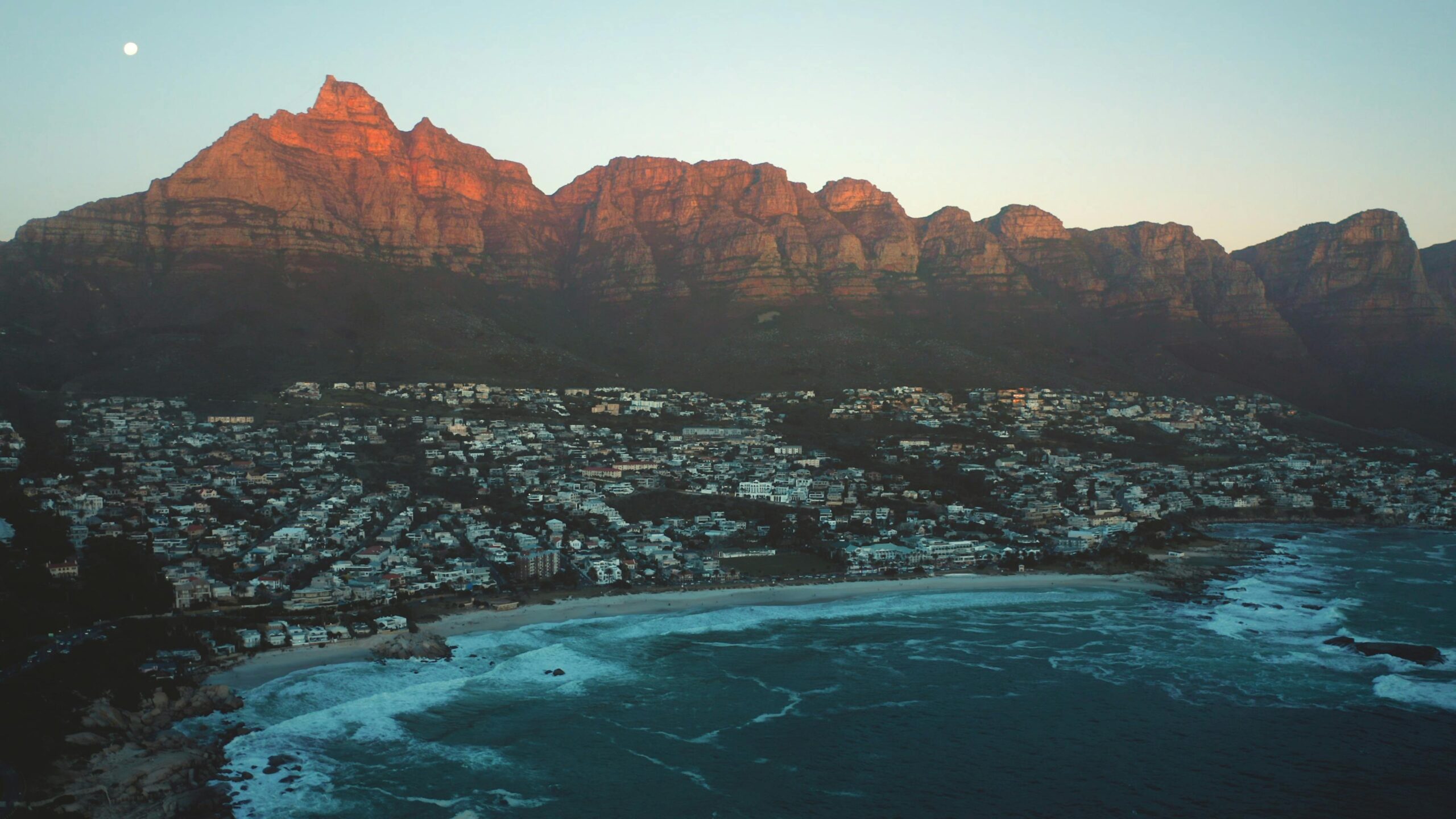 Stunning aerial shot of Cape Town's coastline with Twelve Apostles Mountain at sunset.